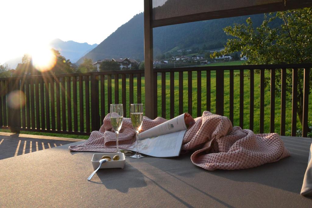 uma mesa com taças de vinho e um livro sobre ela em Apartment Pyrus em Tirolo