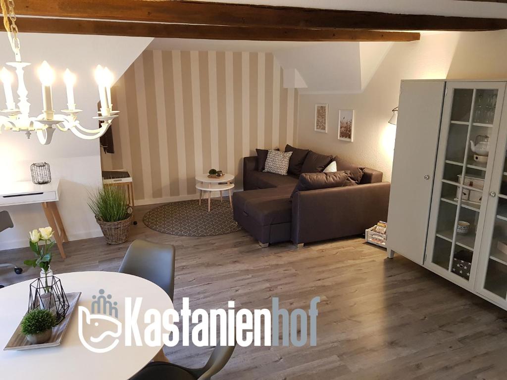 a living room with a couch and a table at Neu renovierte Ferienwohnung mit Poolhaus & Sauna auf dem Bauernhof in Oetzen