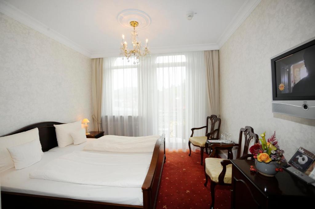 Postel nebo postele na pokoji v ubytování HELIOPARK Bad Hotel Zum Hirsch