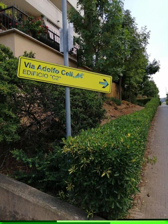 um sinal de rua amarelo na berma de uma estrada em Porta di Roma locazione turistica em Roma