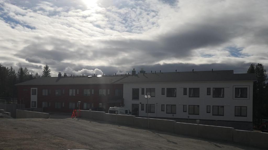 a large white building with a cloudy sky in the background at Levi Jaihki Apartments in Levi