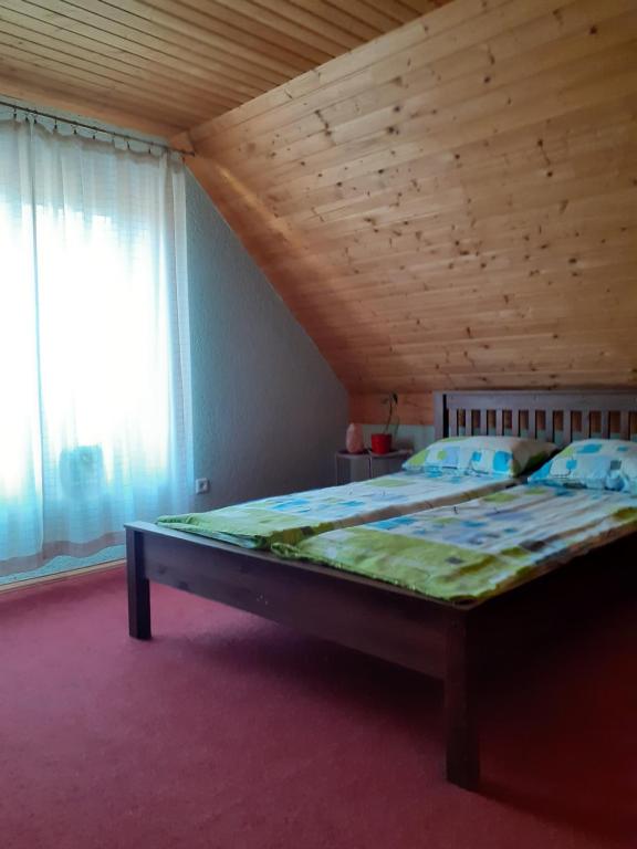 a large bed in a room with a wooden ceiling at Holiday home in Ogre