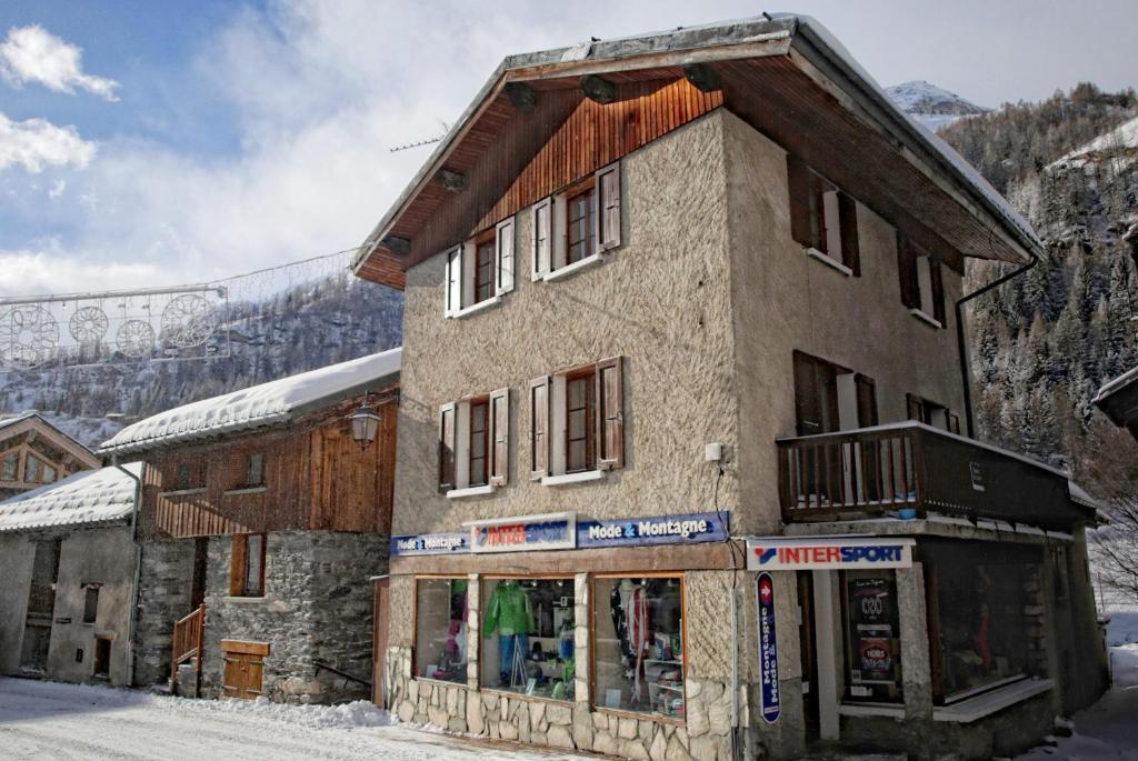 a building with a store in front of a mountain at Chalet Le Loup - charming Tignes ski chalet in a superb location in Tignes