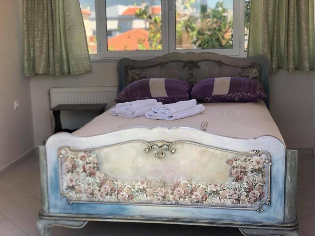1 cama con 2 toallas y ventana en Art Suites Mesologgi, en Mesolongi