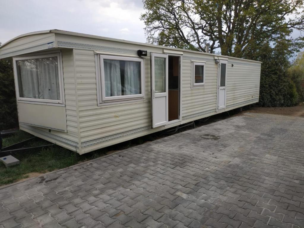 a white caravan sitting on top of a driveway at 4U Pokój w domku holenderskim Rooms in Tinyhouse in Zgorzelec