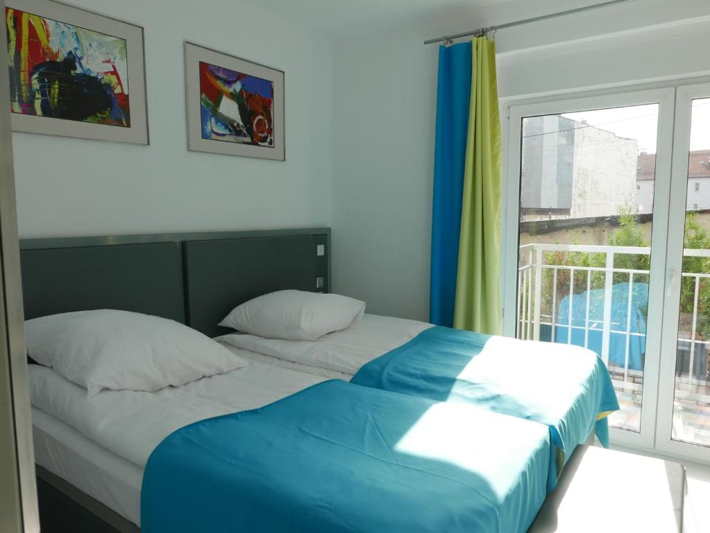 een slaapkamer met 2 bedden en een raam bij ROOMS BYTOM in Bytom