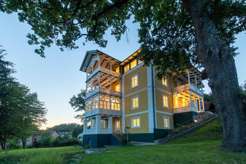 韋爾特湖畔費爾登的住宿－Villa Bella Vista，树大房子的图象