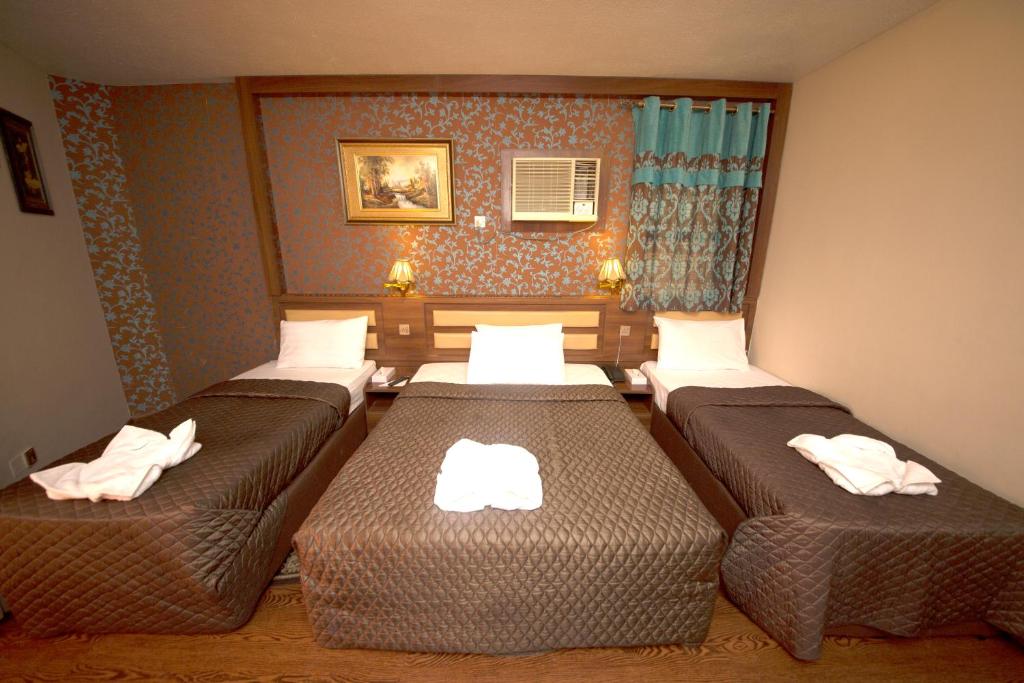 Habitación de hotel con 3 camas y toallas. en Downtown Hotel, en Dubái