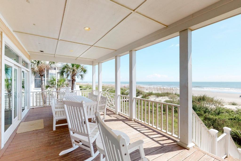 - une terrasse couverte avec des chaises blanches et une vue sur la plage dans l'établissement Ocean Boulevard 802, à Isle of Palms
