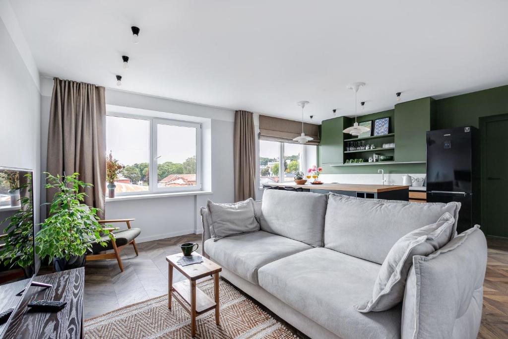 a living room with a couch and a kitchen at Old-New Apartment in Central Kaunas in Kaunas