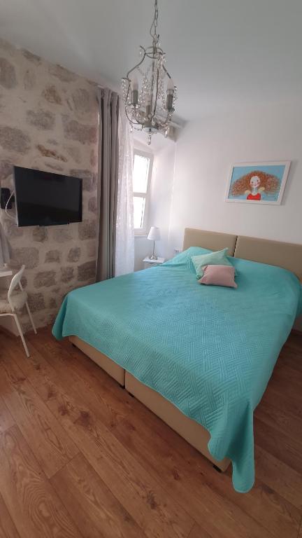 a bedroom with a blue bed and a tv at Rilati palace Dubrovnik 3 in Dubrovnik