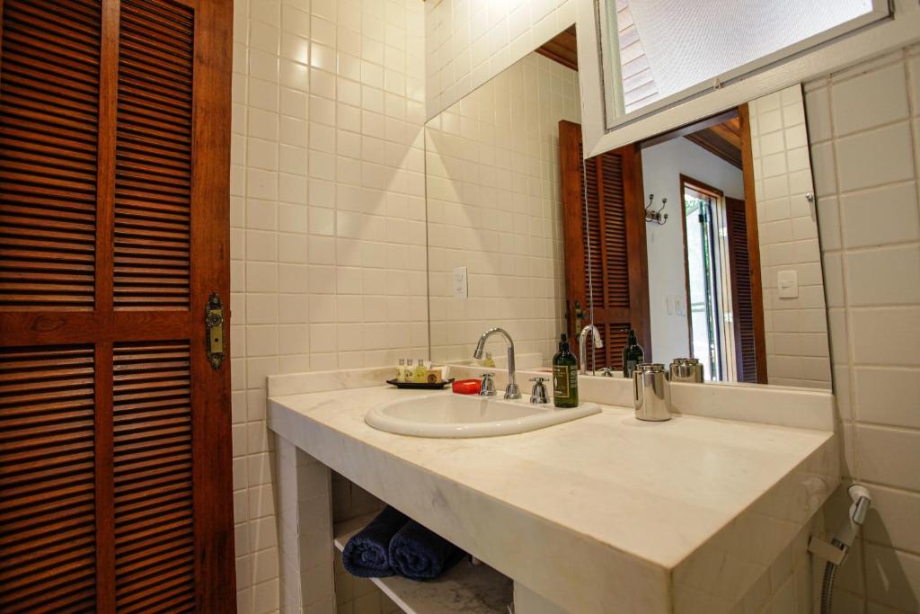 a bathroom with a sink and a mirror at Atlantica Jungle Lodge in Abraão