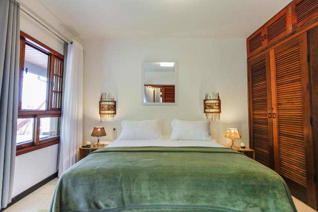 a bedroom with a large bed and a mirror at Atlantica Jungle Lodge in Abraão