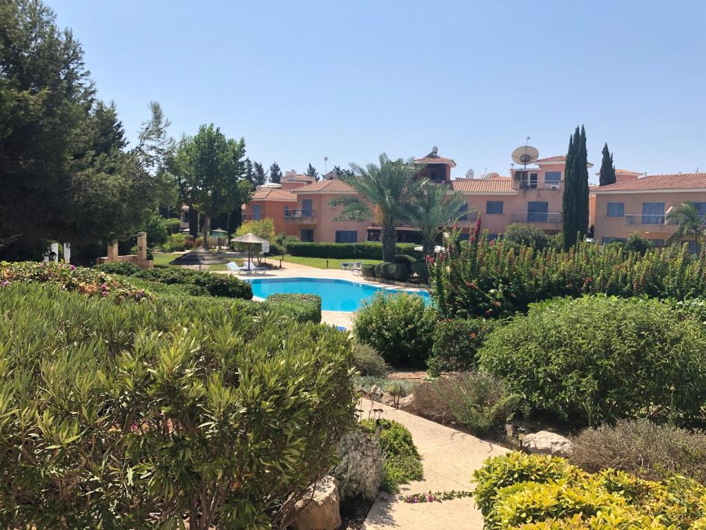 a garden with a swimming pool in a resort at Limnaria Villas - comfy 2 bed, 2 bath ground floor apartment in Paphos