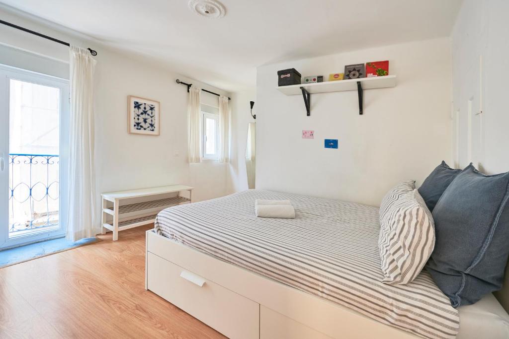 um quarto branco com uma cama e uma janela em MEET LISBOA | Your Home in Lisbon | City Centre em Lisboa