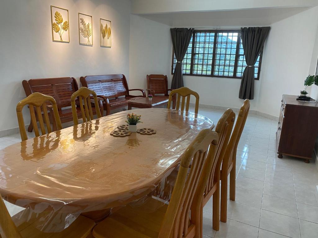 a dining room with a wooden table and chairs at Cameron Highland Cozy Homestay in Tanah Rata