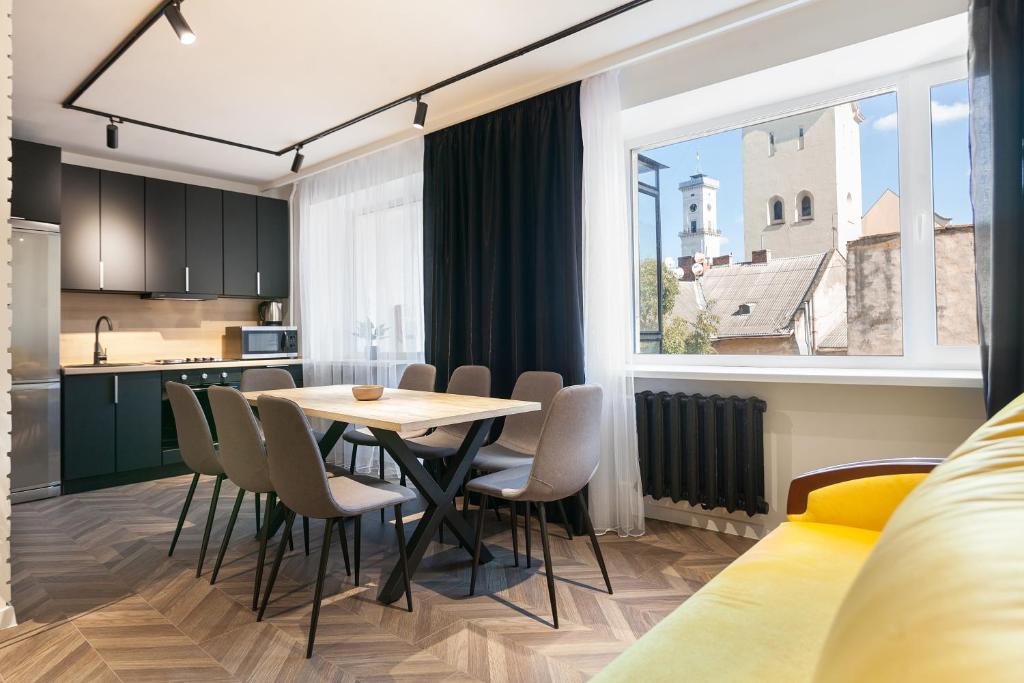 eine Küche und ein Esszimmer mit einem Tisch und Stühlen in der Unterkunft LEOGRAND Apartments on Svobody avenue 6-8 in Lwiw
