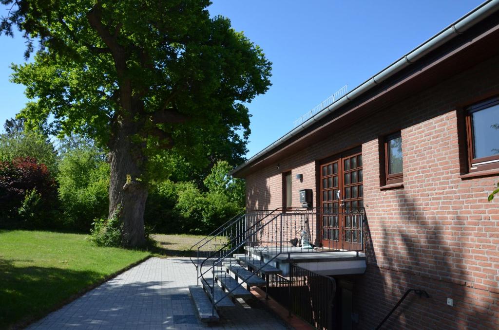 a group of benches next to a building with a tree at Ferienwohnung am See in Eutin