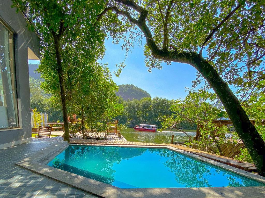 una piscina junto a una casa con un árbol en Casanova Residence, en Río de Janeiro