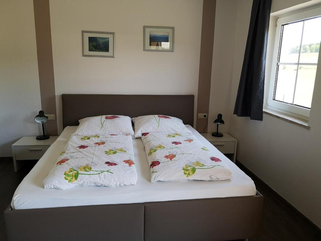 2 Kissen auf einem Bett im Schlafzimmer in der Unterkunft Hubertushof Eifel in Schönbach