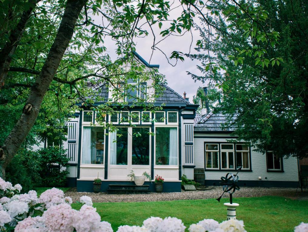 Pastorie Tijdverblijf في Zuidhorn: منزل مع حديقة شتوية في وسط الفناء