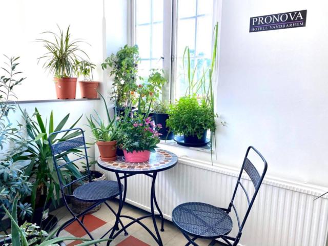 een balkon met een tafel en stoelen en potplanten bij Pronova Hotell & Vandrarhem in Norrköping