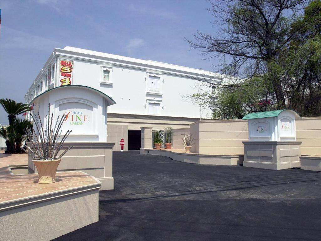 a white building with a sign on it at Hotel Fine Garden Matsuyama in Matsuyama