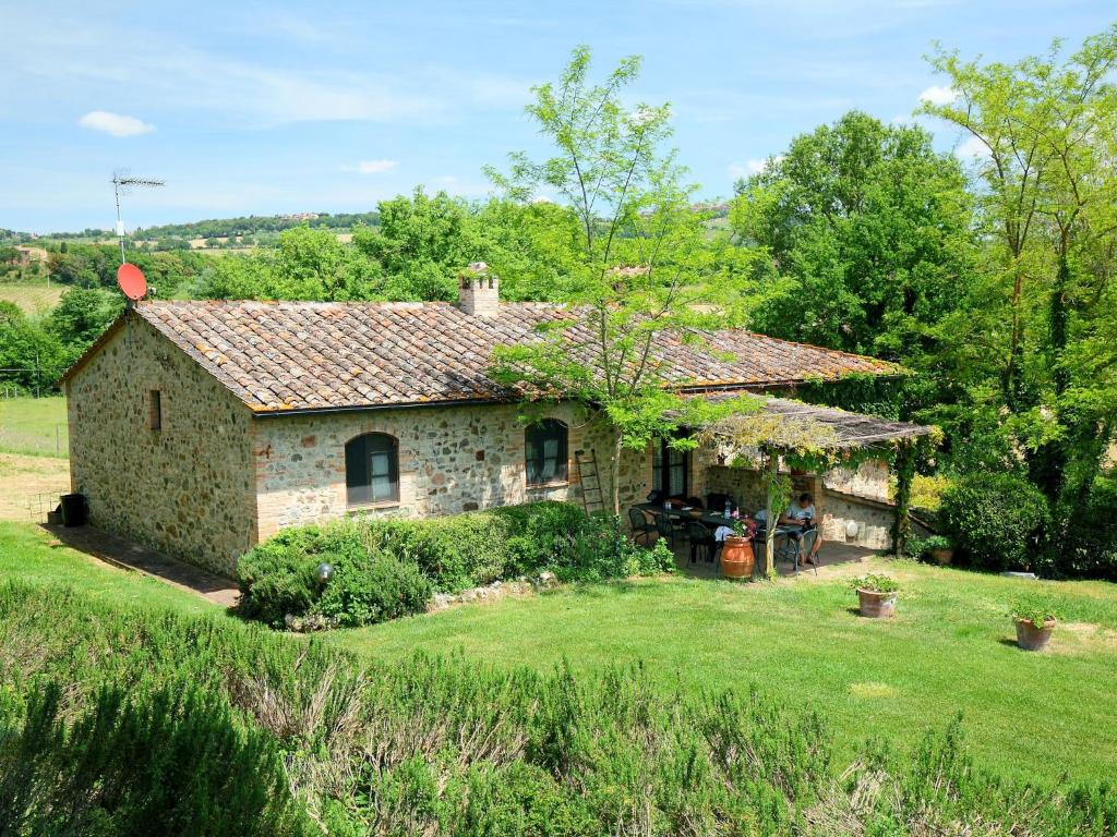 a stone house in a field with a yard at Holiday Home Podere S Giovanni by Interhome in Casole dʼElsa