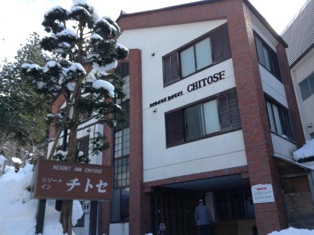 un edificio con una señal delante de él en Resort Inn Chitose, en Nozawa Onsen