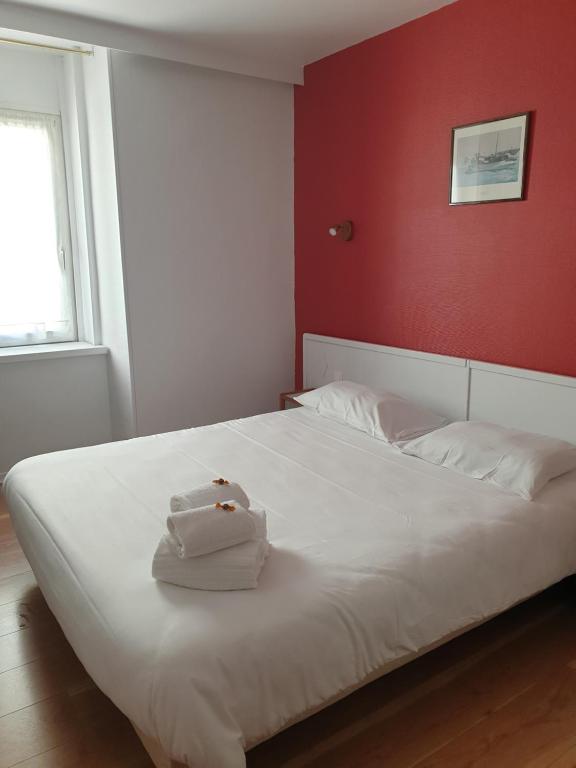 - une chambre avec un lit blanc et un mur rouge dans l'établissement Hôtel Hermance, à Bellegarde-sur-Valserine