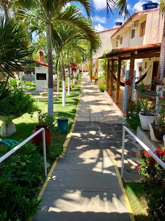 a sidewalk with palm trees and a building at Residencial Portuguesa in Natal