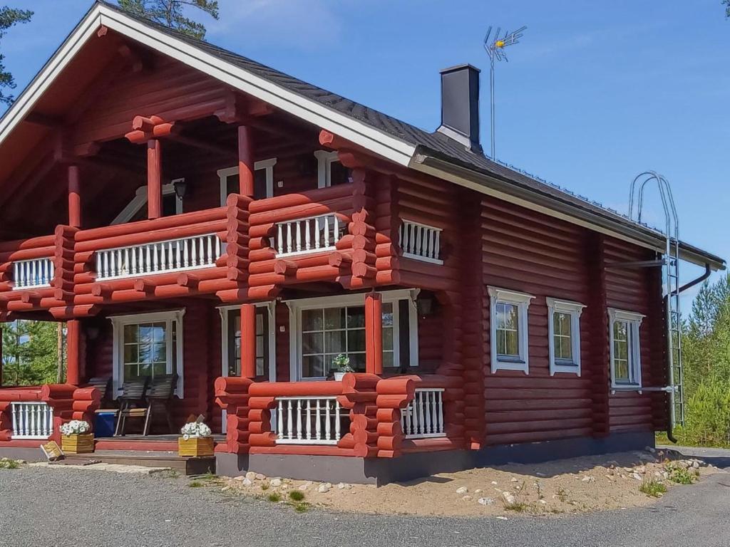 une maison en bois avec des bûches rouges dans l'établissement Holiday Home Harjurinne by Interhome, à Kinnula