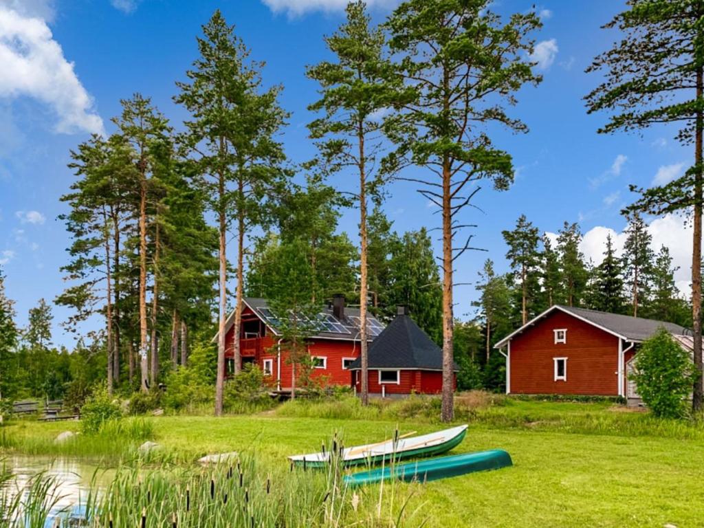 una casa rossa con le barche di fronte di Holiday Home Kallioniemi by Interhome a Toiviaiskylä