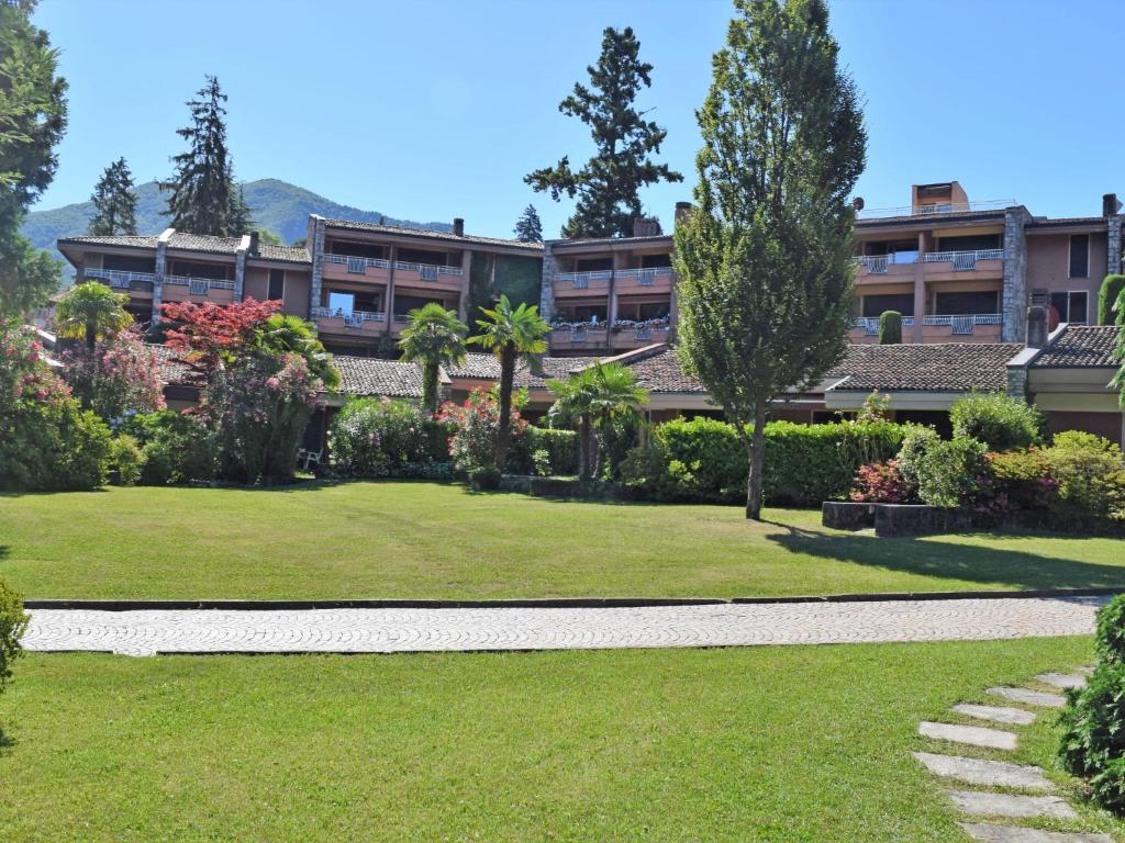ośrodek z zielonym trawnikiem i budynkiem w obiekcie Apartment Hermitage-5 by Interhome w mieście Porto Valtravaglia