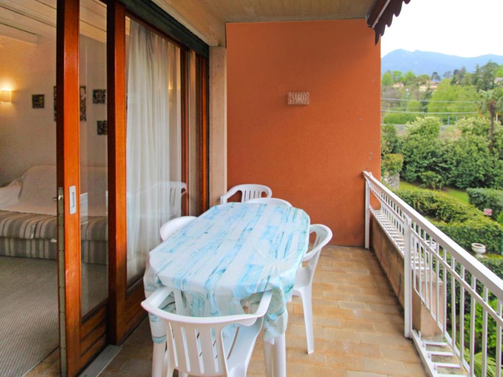 weranda ze stołem i krzesłami na balkonie w obiekcie Apartment Hermitage-5 by Interhome w mieście Porto Valtravaglia