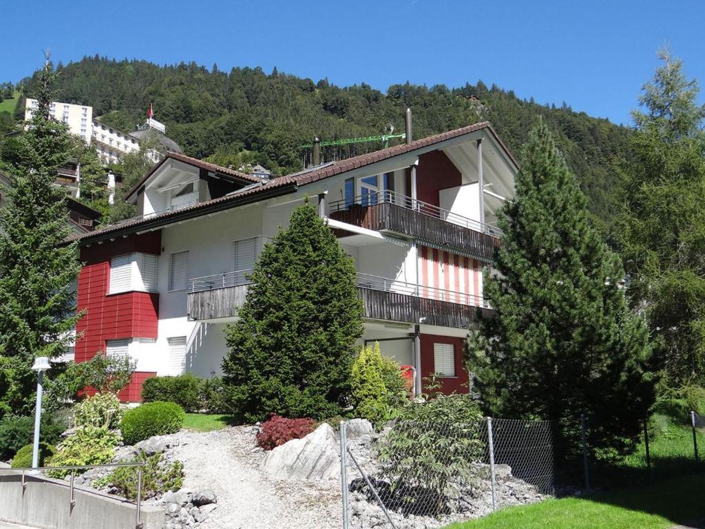 ein Gebäude auf einem Hügel mit Bäumen davor in der Unterkunft Apartment Blumenweg 10 by Interhome in Engelberg