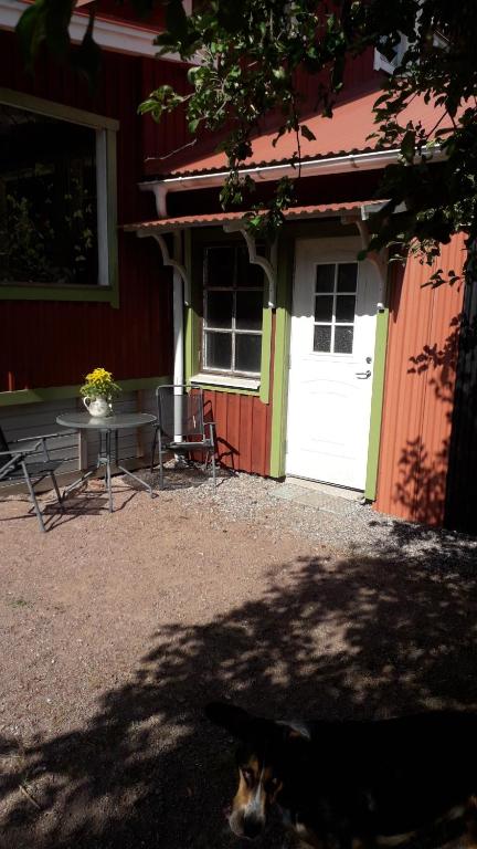 um gato deitado em frente a um edifício com uma mesa e uma porta em Granviks Bed & Breakfast em Björklinge