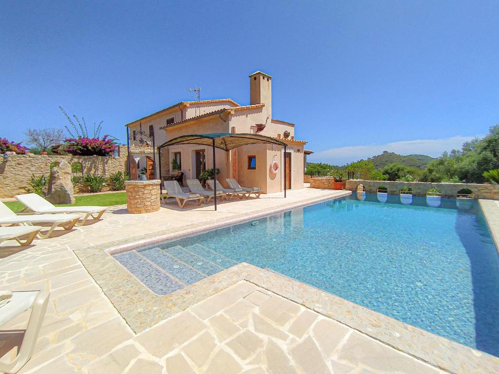 una grande piscina di fronte a una casa di Sa Sinia - Family rural house with pool and mountain views a S'Horta