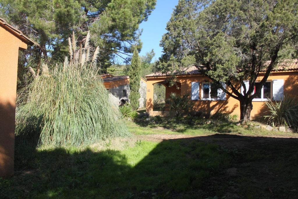 uma casa com um quintal com relva e árvores em Villas Abbartello em Olmeto