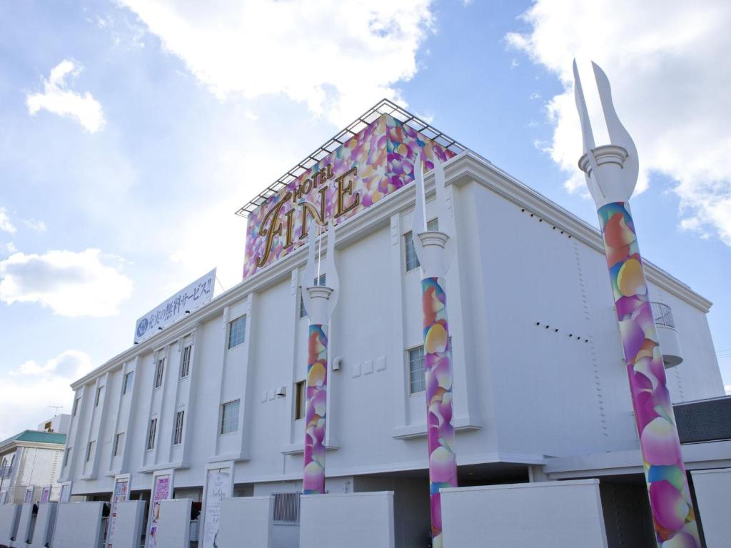a large white building with colorful decorations on it at Hotel Fine Garden Matsuzaka II in Matsuzaka