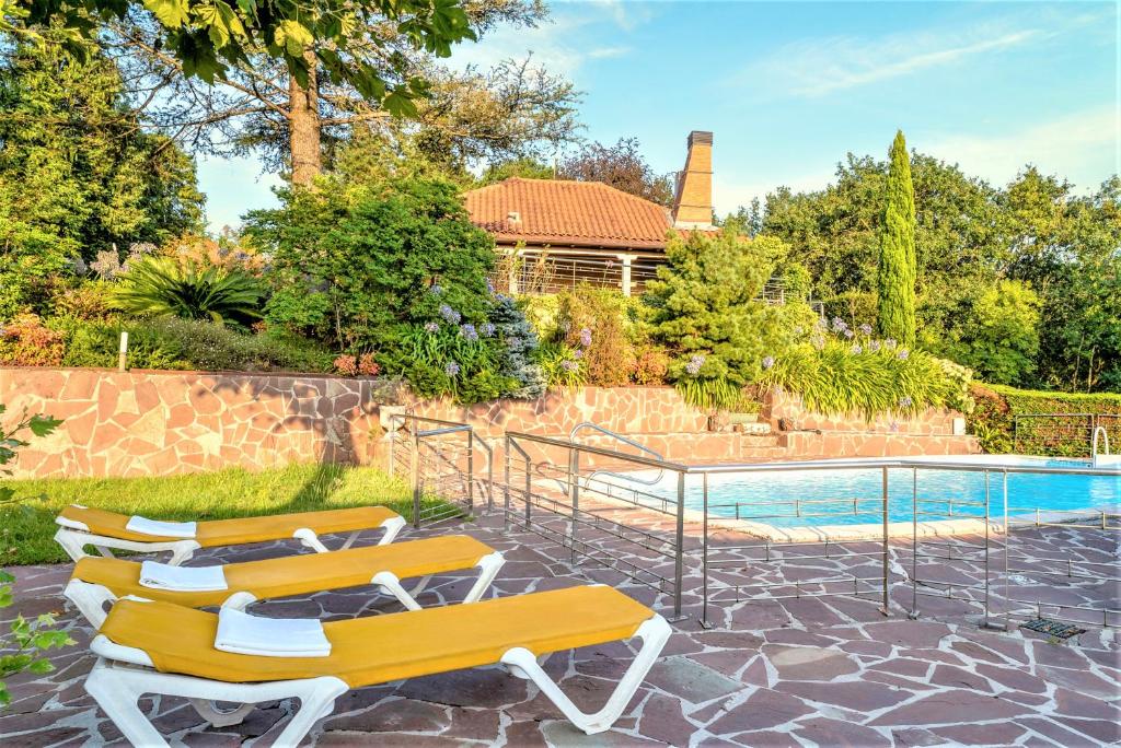 duas cadeiras amarelas sentadas ao lado de uma piscina em Villa Urbasa em San Sebastián