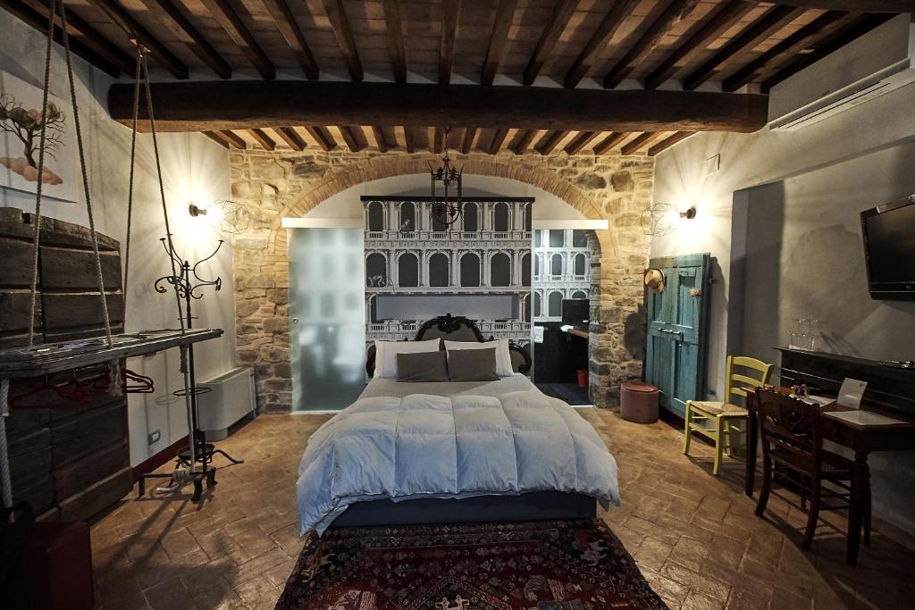 sypialnia z dużym łóżkiem w kamiennym pokoju w obiekcie il burellino w mieście Montalcino
