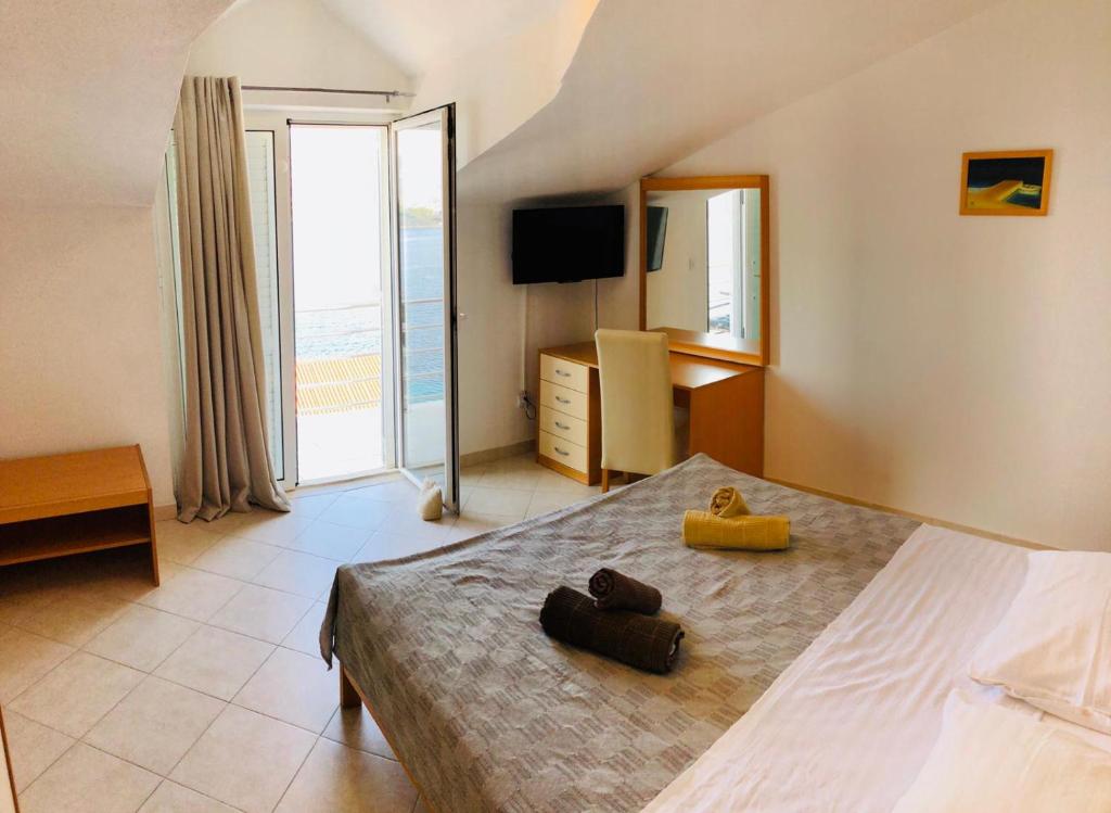 a bedroom with a large bed and a television at Apartments Mare in Korčula