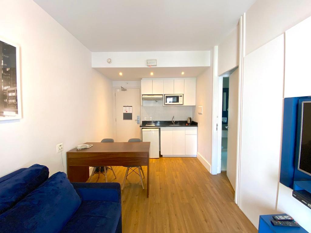 ein Wohnzimmer mit einem blauen Sofa und einem Tisch in der Unterkunft Apartamento conforto - Itaim Bibi in São Paulo