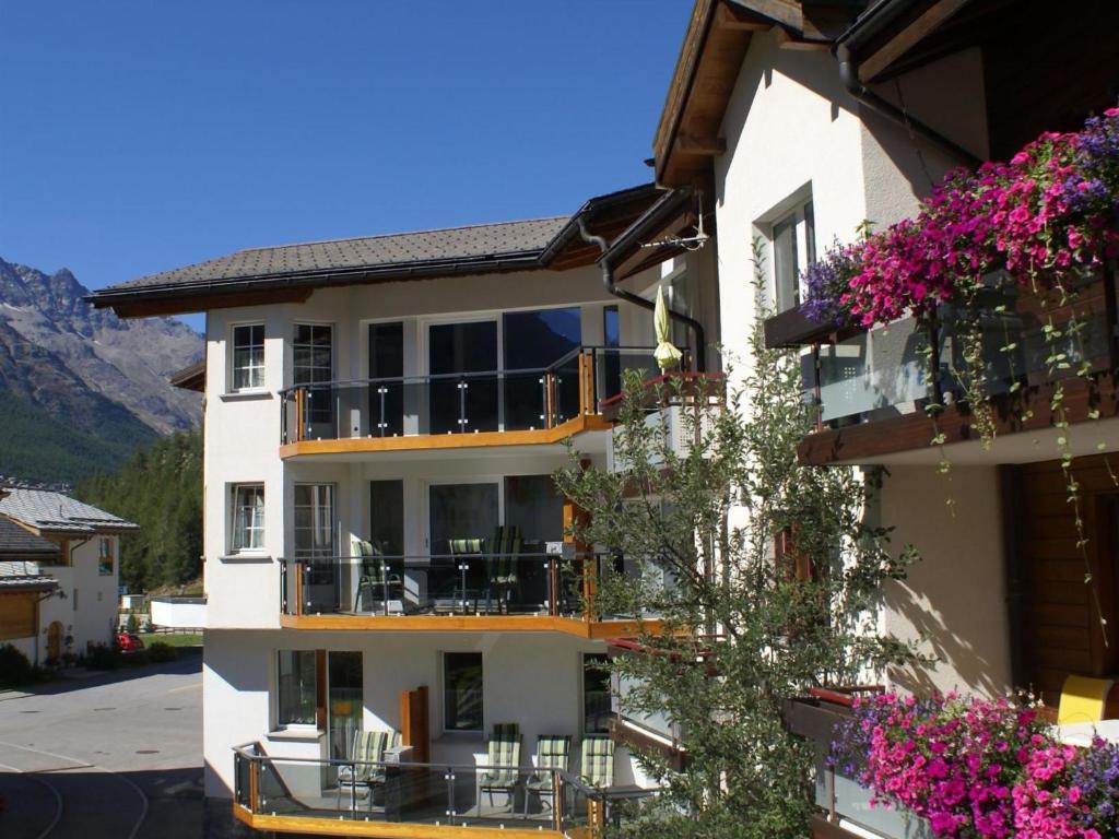 a apartment building with flowers on the balconies at Apartment Haus Alpenrose by Interhome in Saas-Almagell
