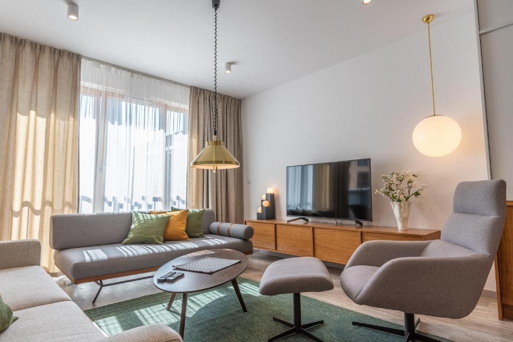 a living room with a couch and a tv at City Lights Apartments in Kraków