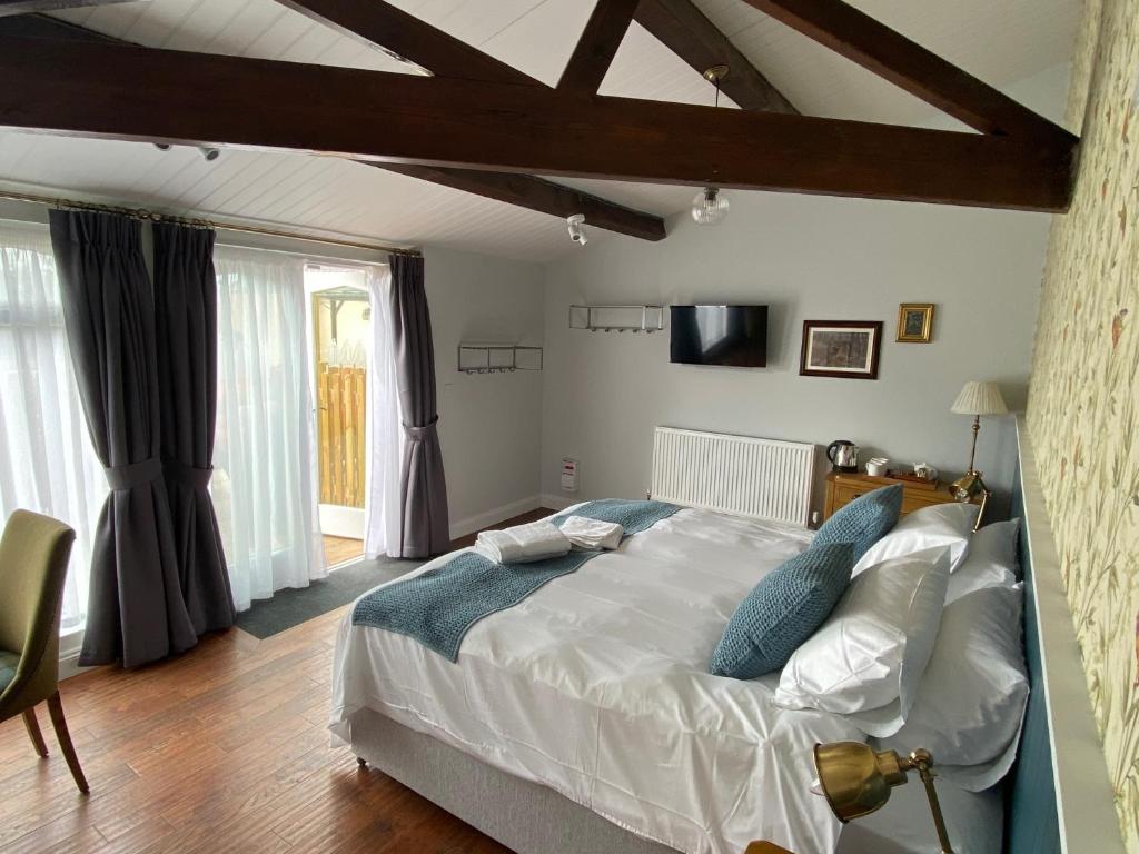 a bedroom with a large bed with blue pillows at Three Bishops Inn in Newport