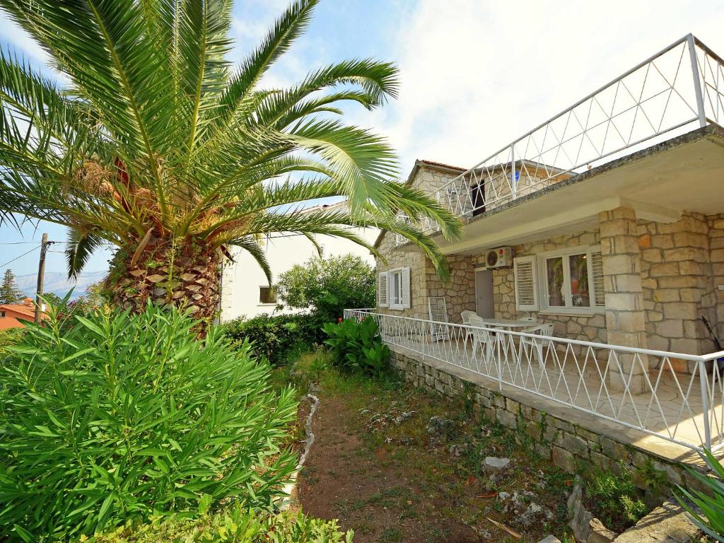 a house with a palm tree in front of it at Holiday Home Villa Palma by Interhome in Postira