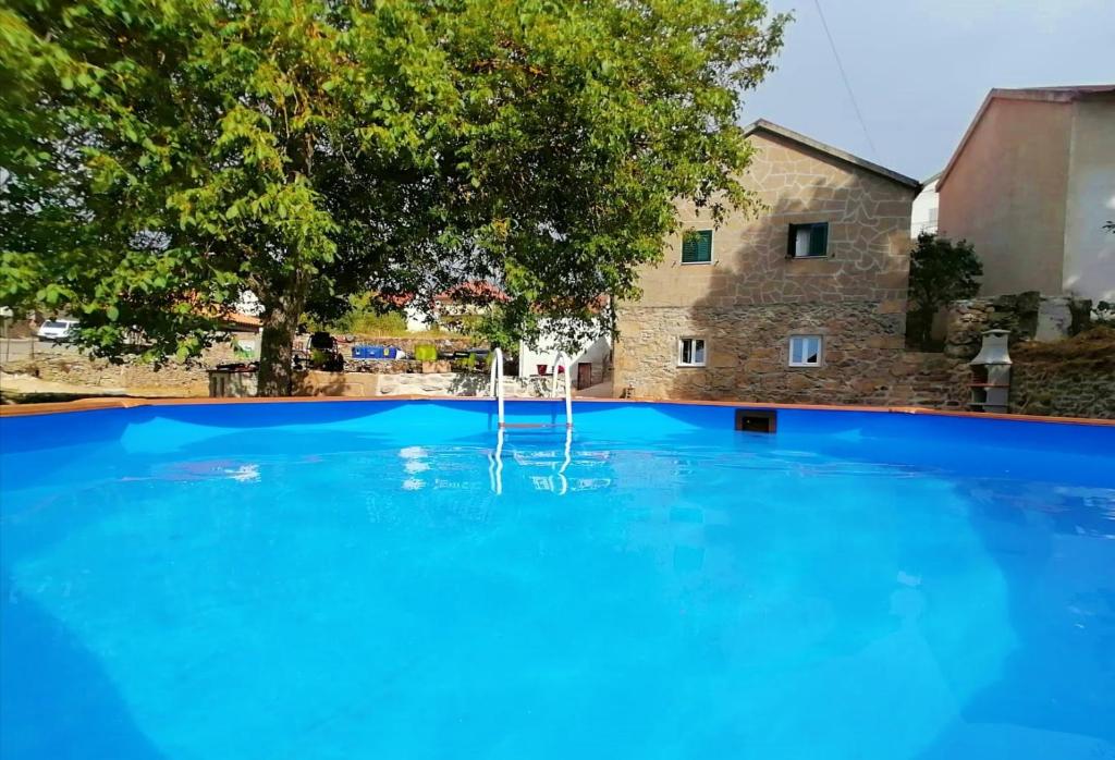 une grande piscine bleue en face d'un bâtiment dans l'établissement Cantinho D'Aldeia, à Guarda