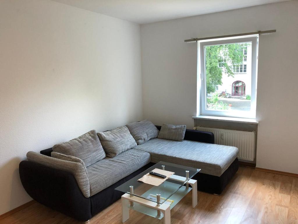 a living room with a couch and a table at Ruhige Wohnung bei der Burg im OG2 in Kröllwitz